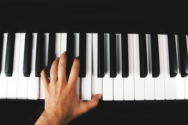 A hand playing piano keys